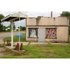 Lefors: : HOMEMADE QUILTS grace the windows of an abandoned gas station.